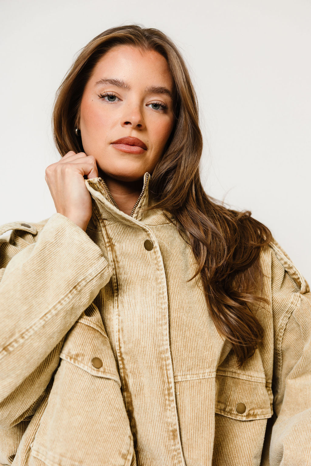 Model in the Saint washed corduroy boyfriend jacket in sandy beige with a collar and snap front