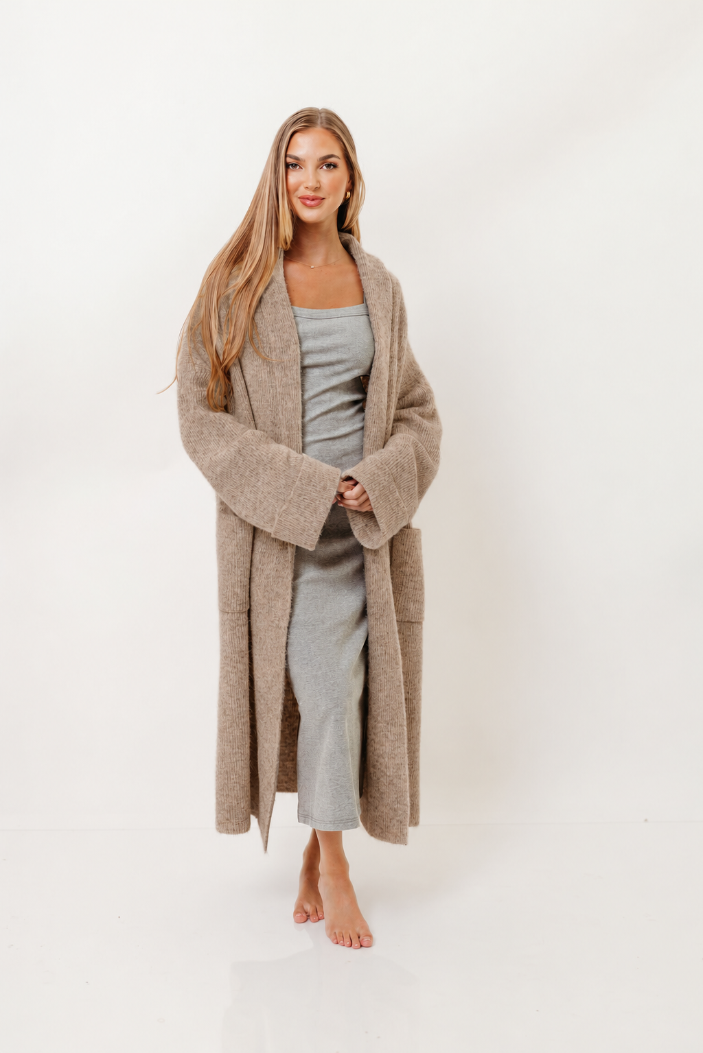 Model in the Amina ribbed knit long cardigan in light mocha, an open-front knee-length knit worn over a grey lounge set