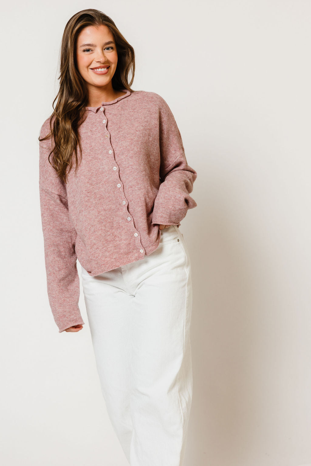 Model in the Piper button-front cardigan in dusty mauve, worn with a white skirt